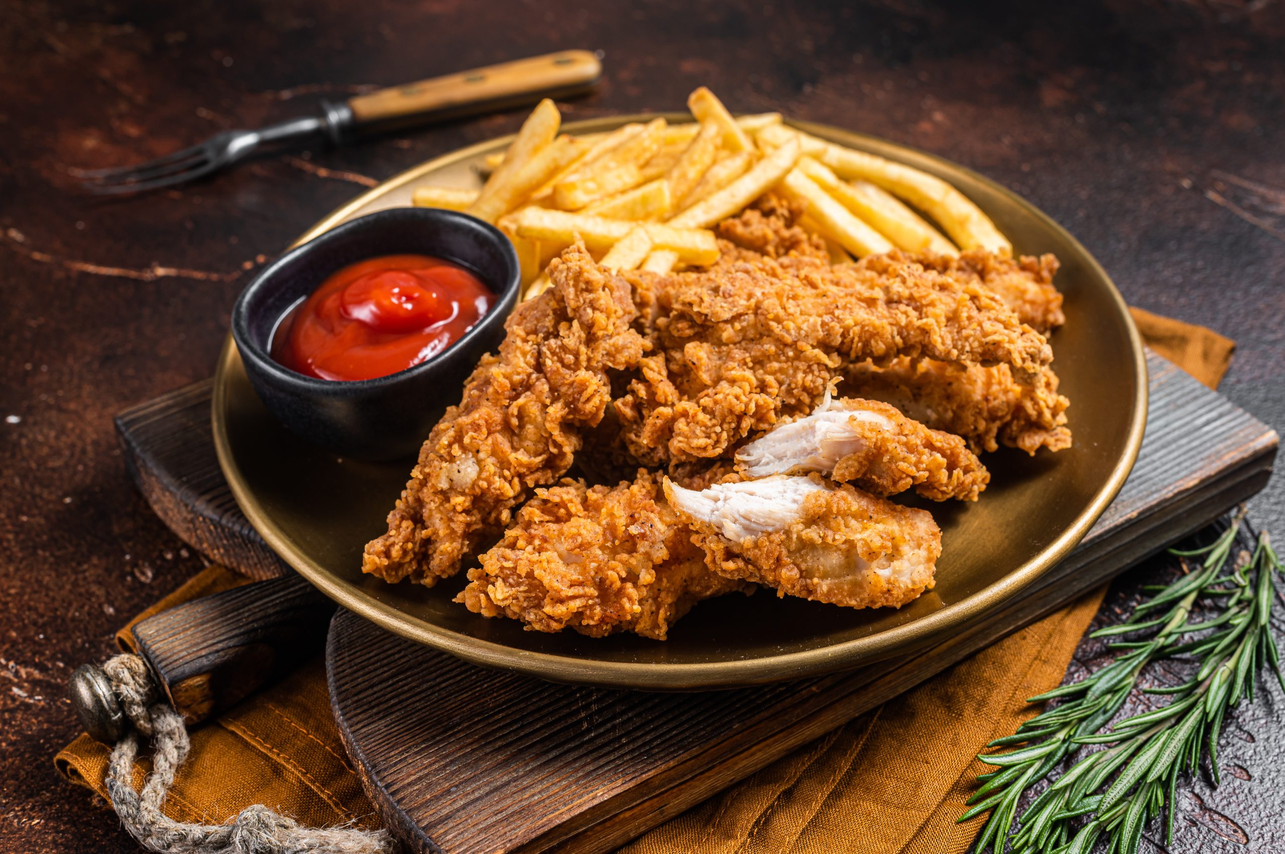 Fried Breaded chicken tender strips with french fries and tomato